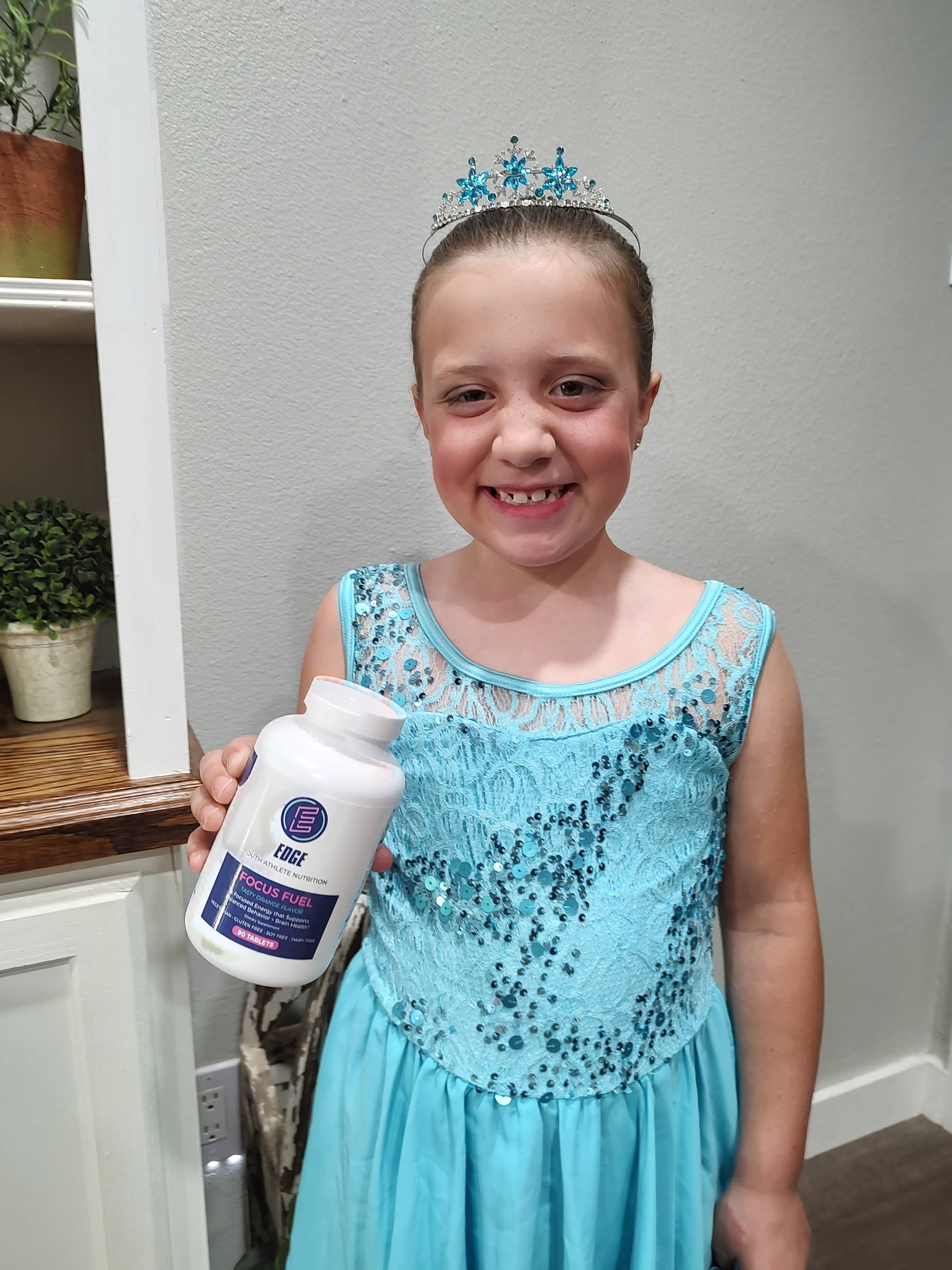 This is a young dancer who is holding a bottle of Focus Fuel because she is happy with her experience with Focus Fuel by EDGE.